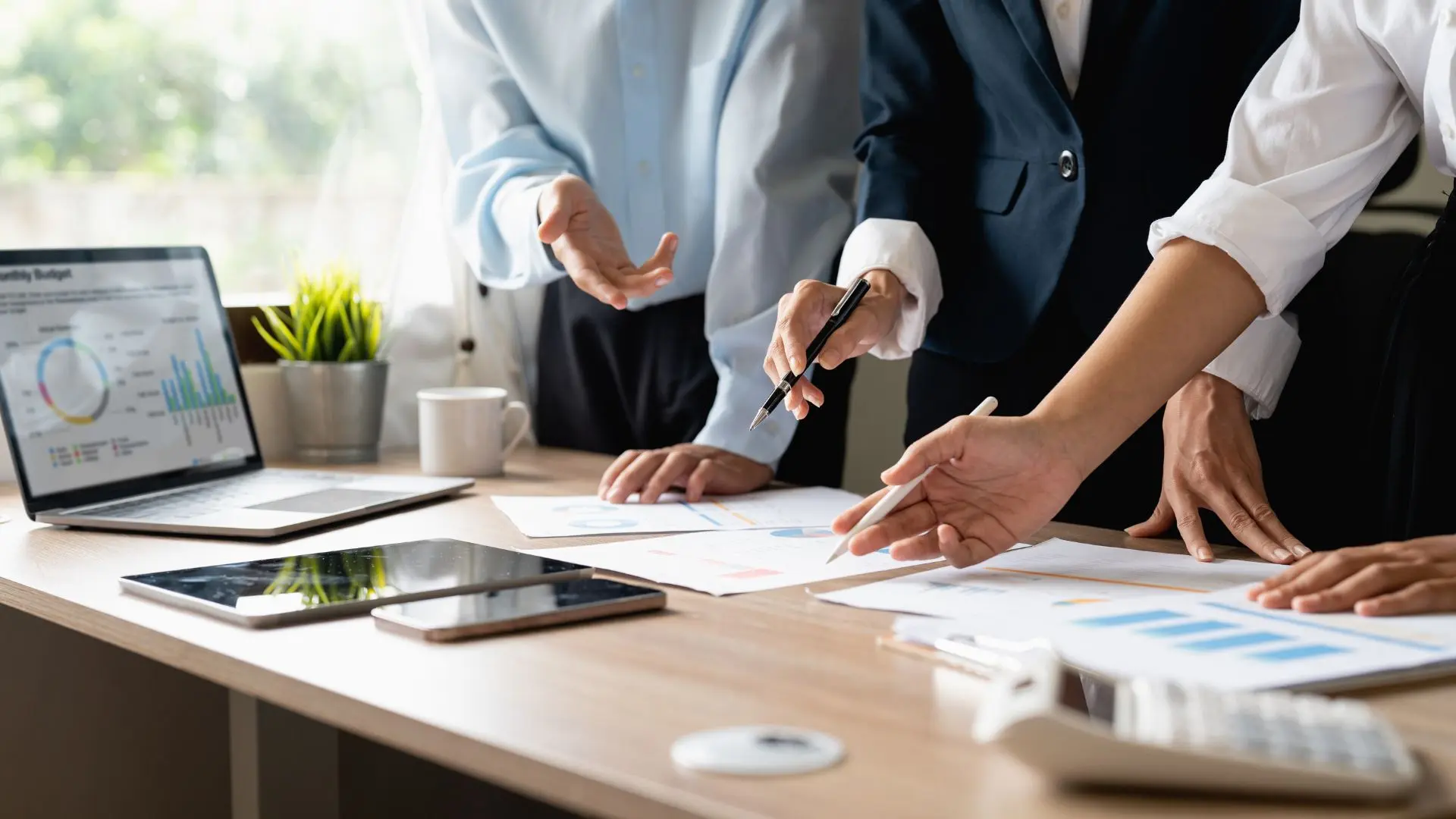 IT leaders and experts jointly analyze data, charts, and strategy documents at a conference table.