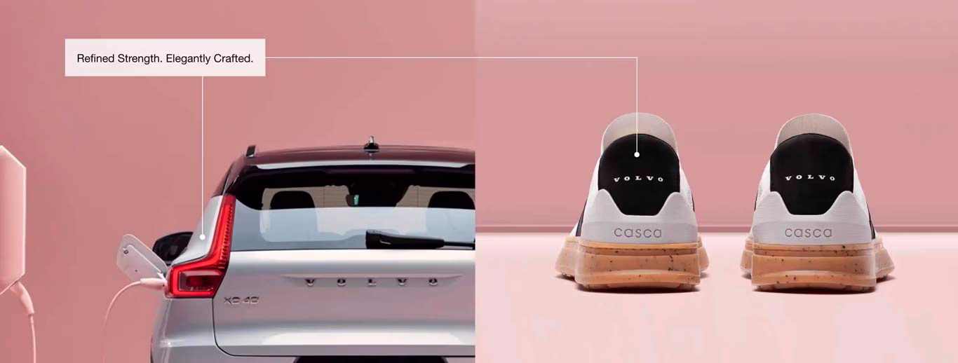 Rear view of a Volvo XC40 Recharge and Casca sneakers, both featuring Volvo branding, displayed against a pink background with the tagline 'Refined Strength. Elegantly Crafted.'