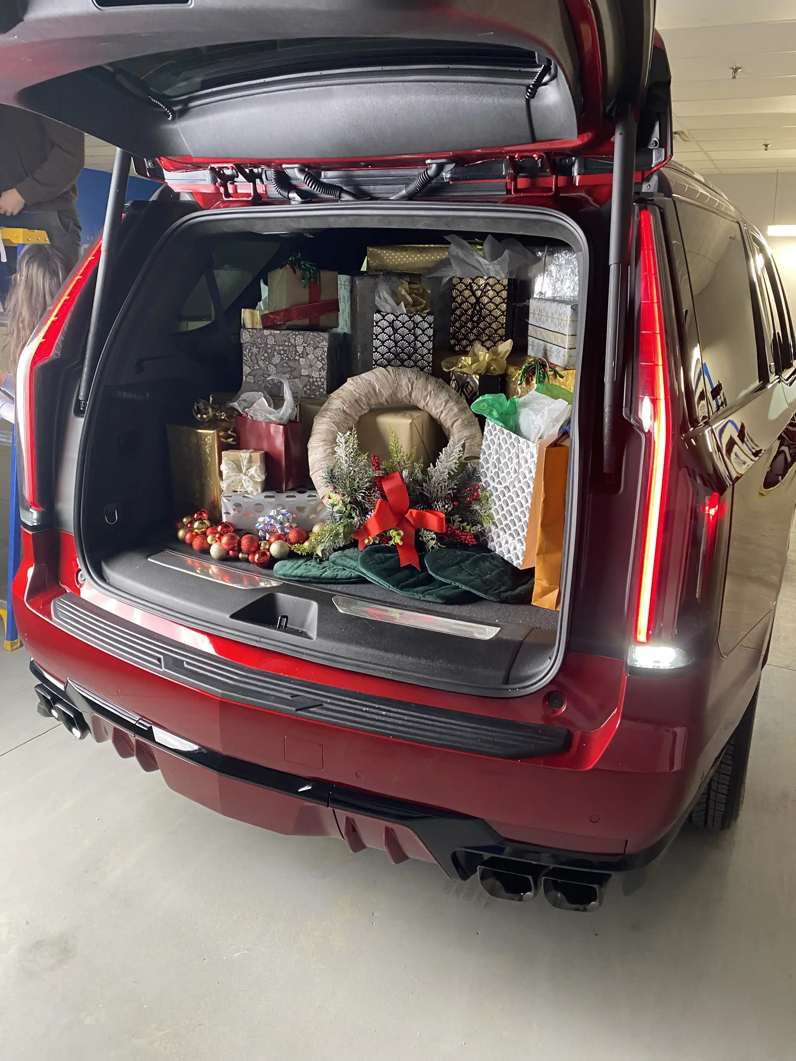 Cadillac SUV trunk packed with Christmas presents and décor for a holiday promo shoot.