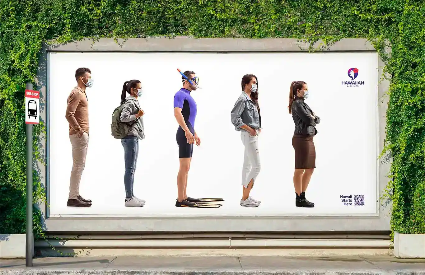 <Bus stop advertisement for Hawaiian Airlines featuring a lineup of masked travellers, including a man in snorkel gear, emphasizing a journey to Hawaii.>