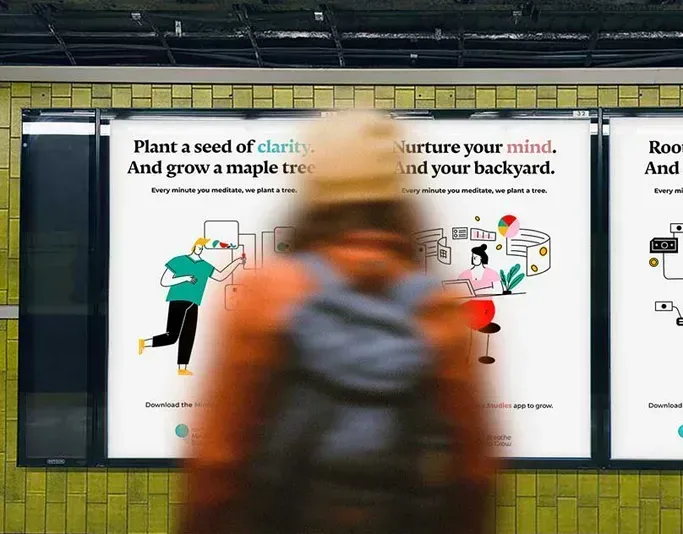 Blurred pedestrian walking past illustrated mindfulness campaign posters in a transit shelter, promoting meditation and tree planting.
