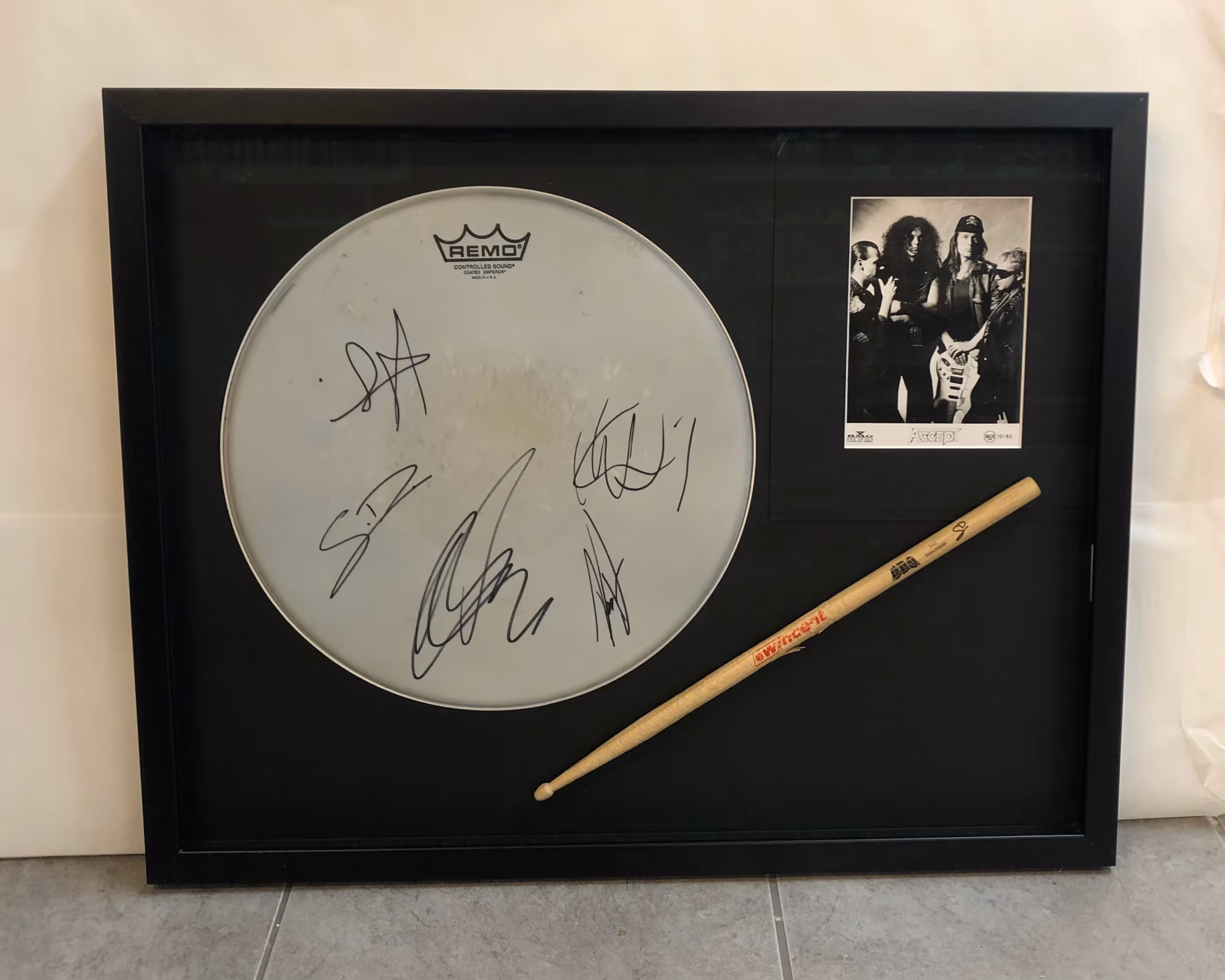 Inramat trumskinn och trumstock, båda signerade av medlemmarna i rockbandet Papa Roach