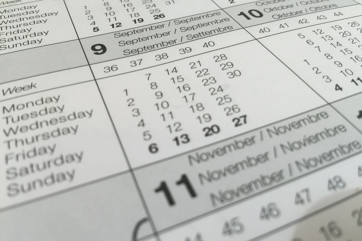 Detailed close-up of a calendar displaying months in several languages.