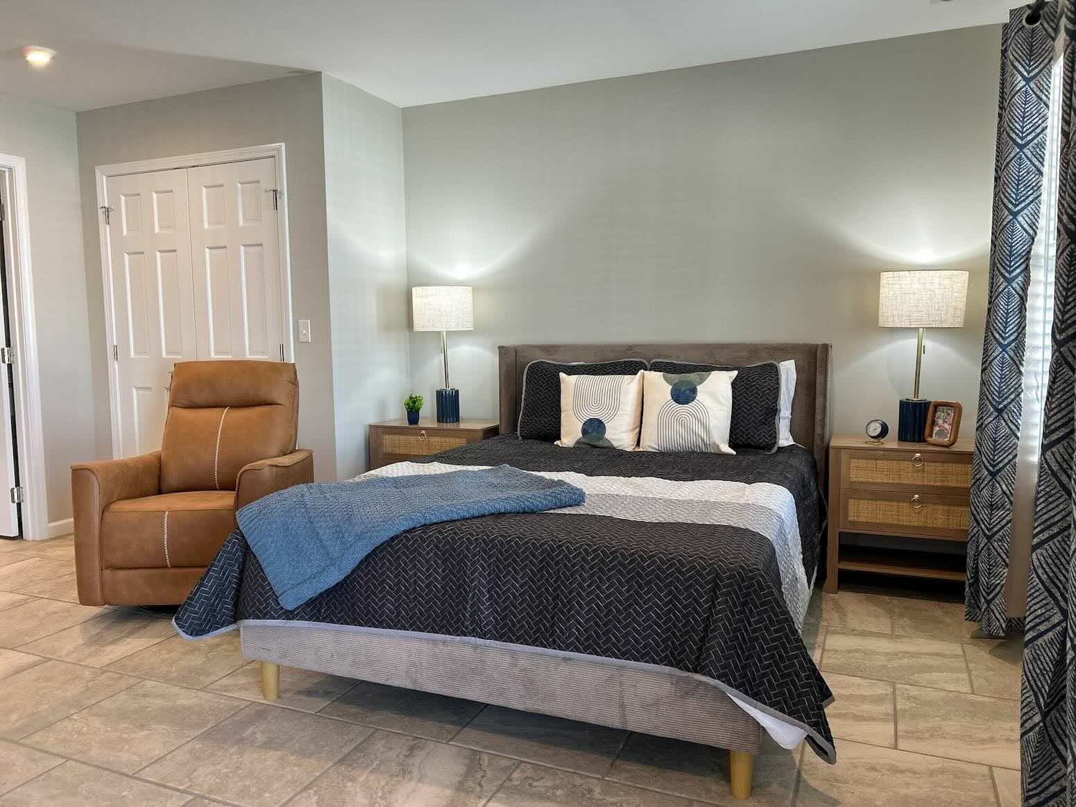 Lake House Assisted Living apartment showing bed and chair at River's Bend.