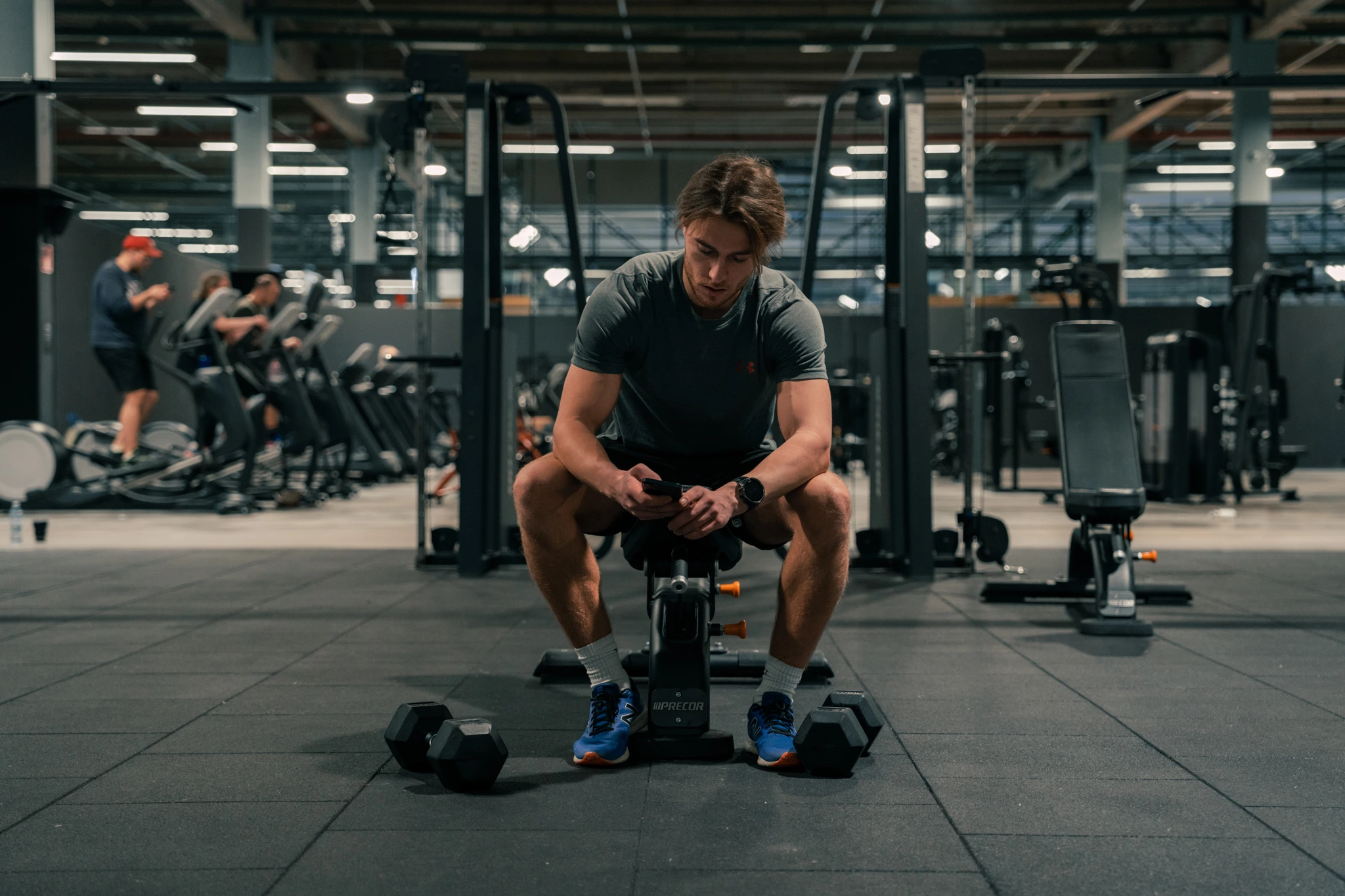 Kuntosaliharjoittelija tarkistaa päivän treeniohjelman AITOFIT-sovelluksesta.