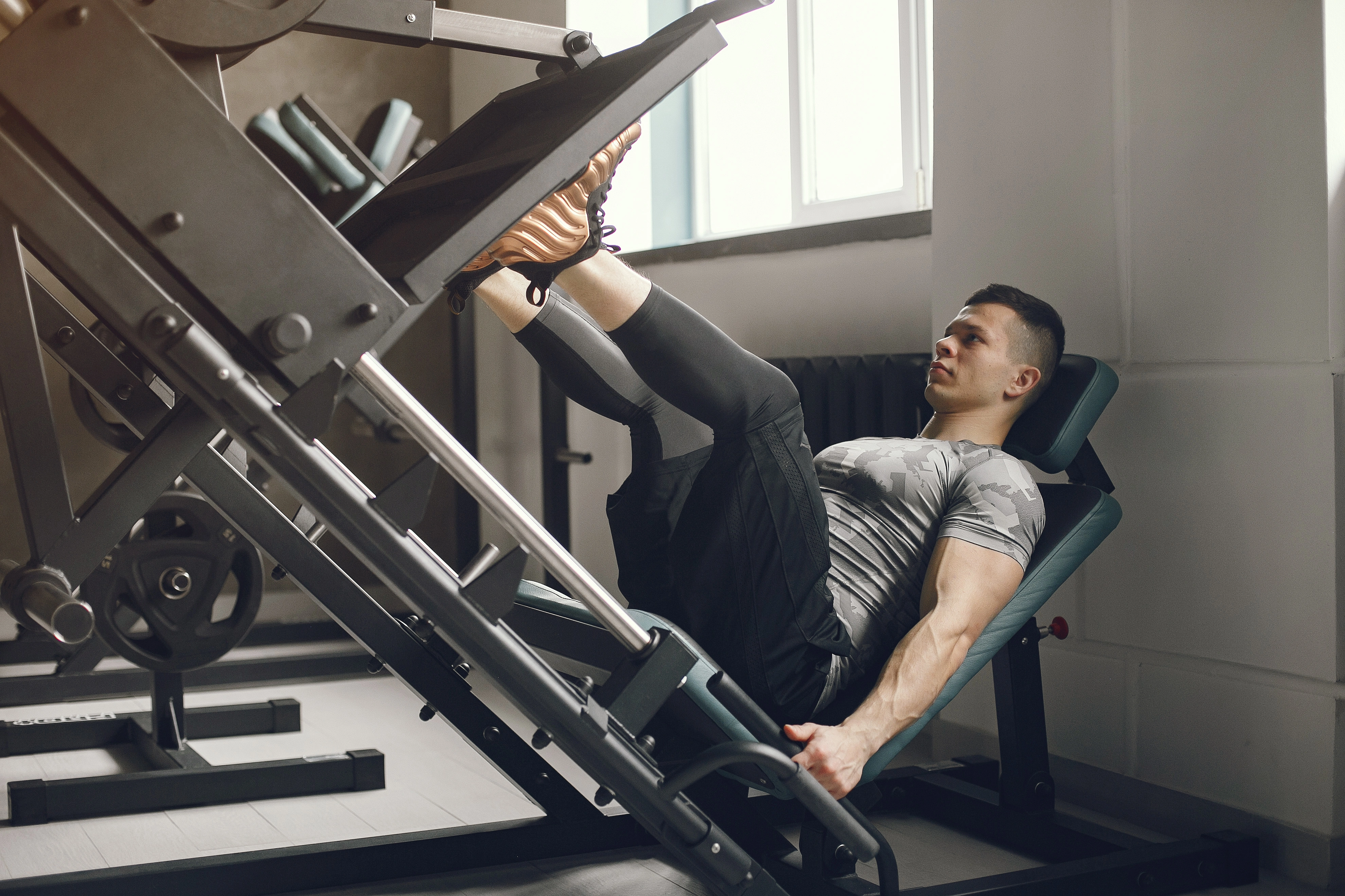 A lifter performing a heavy set on the leg press at the gym; creatine improves performance especially in short, maximal sets.