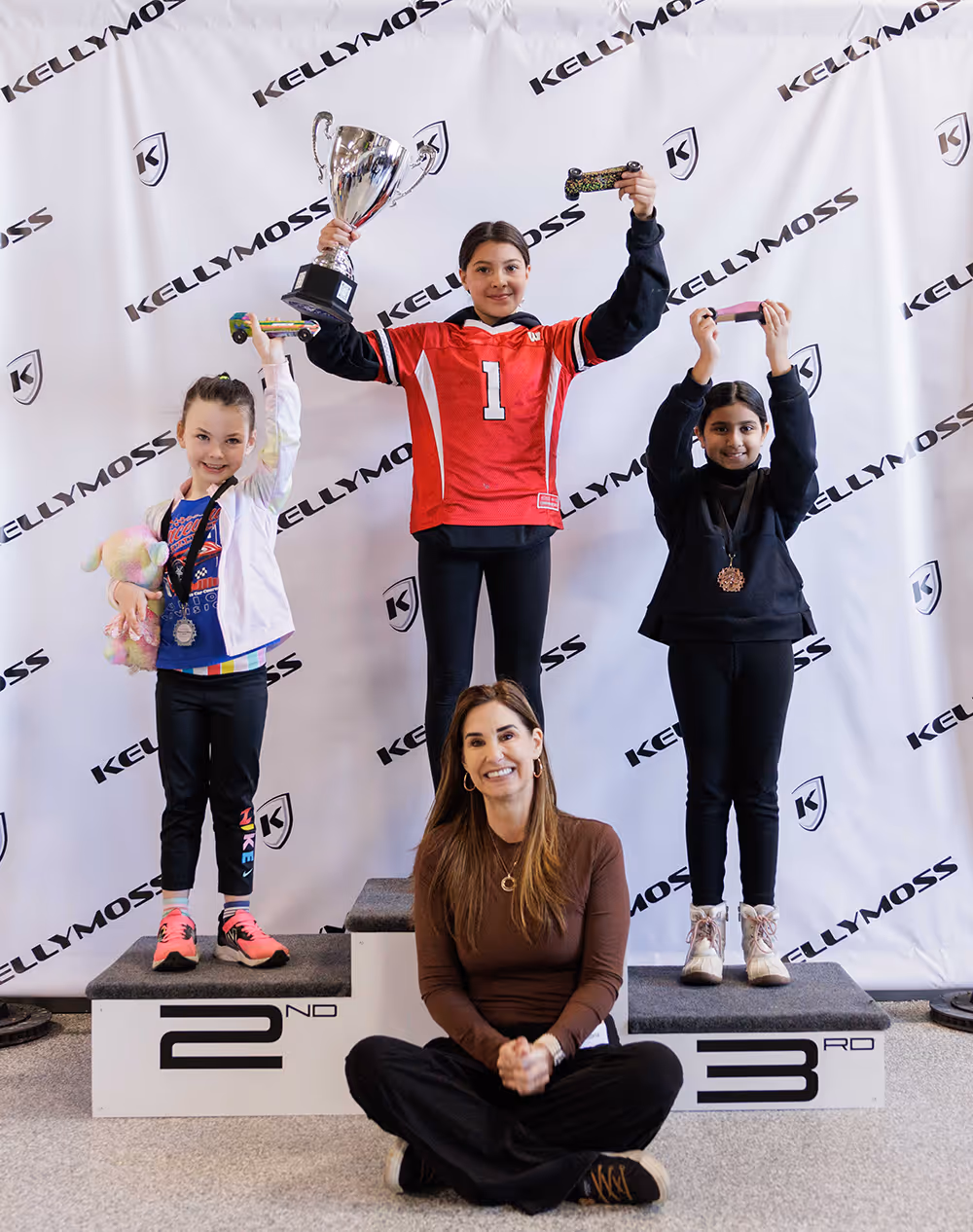 Co-owner Victoria Thomas with this year's Pinewood Derby winners aged 3 - 10