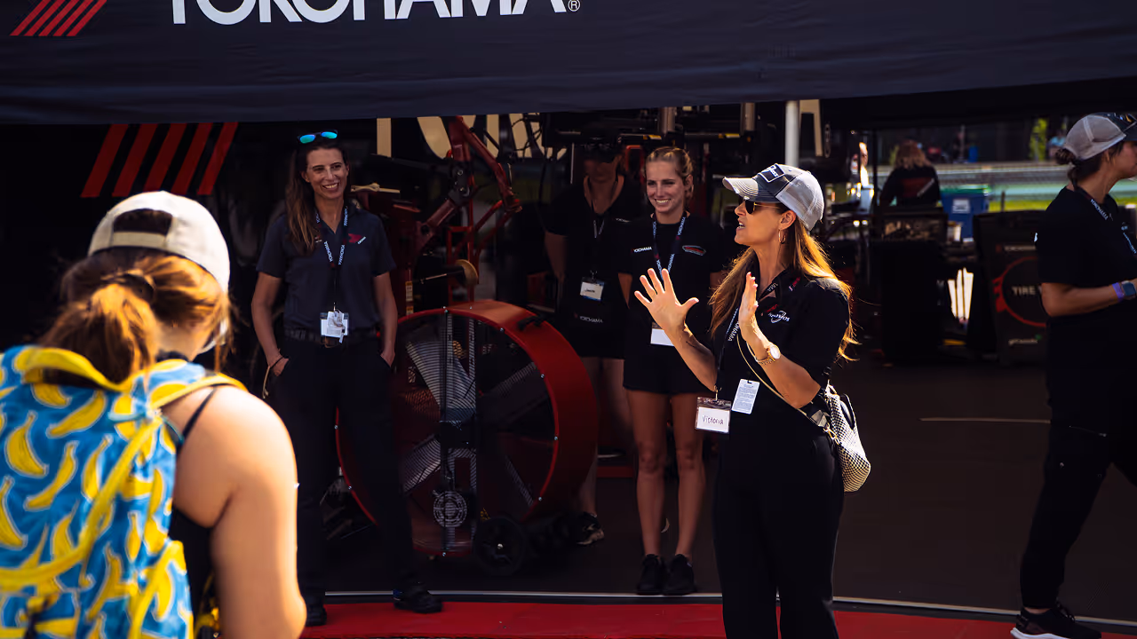 Girl Scouts participating in a Kellymoss Motorsports Mastery team challenge inside a real racing paddock.