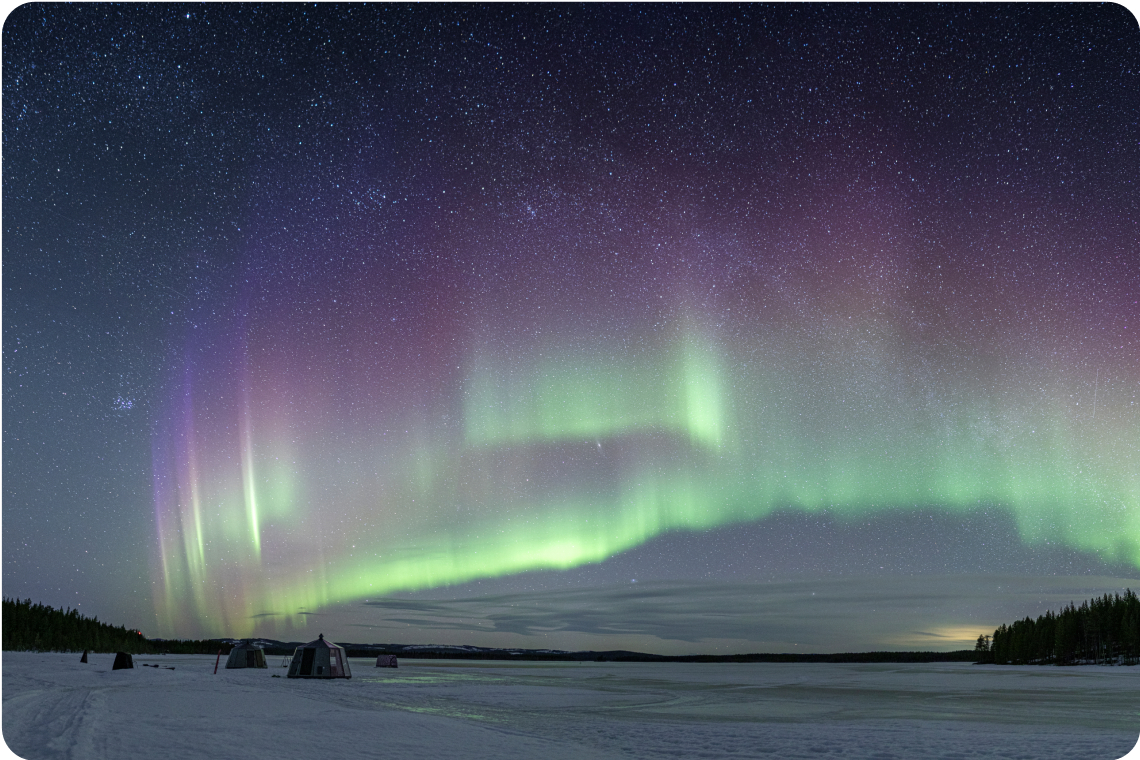 Aurora Borealis over glass cabins in Jokkmokk