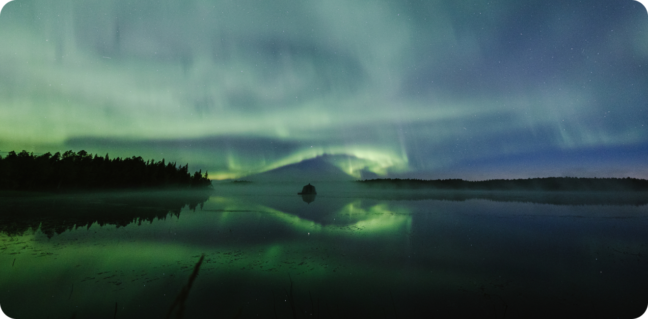 Northern lights creating a swirling shape around a hut