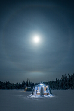 Two glass cabin under lunar halo in Swedish Lapland