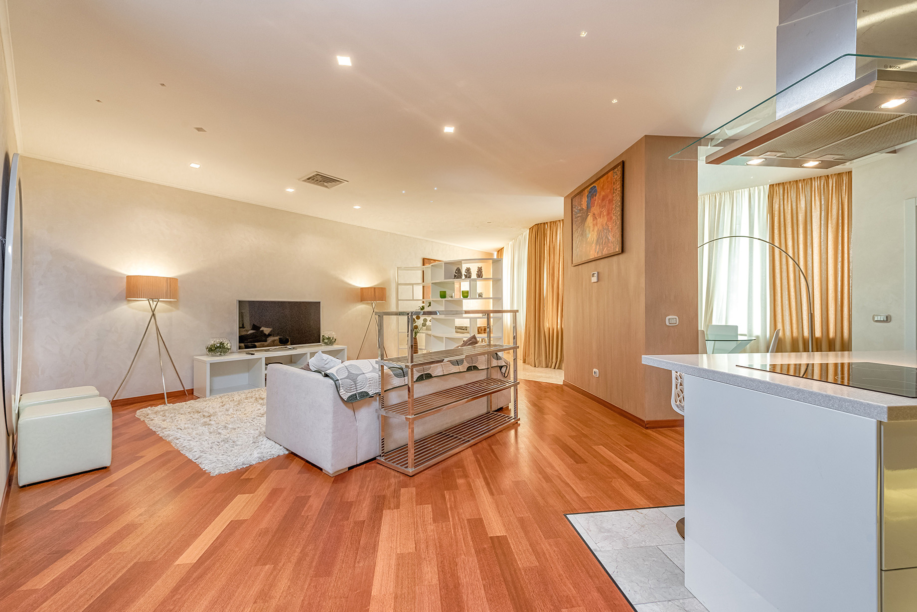 Open-plan living and kitchen with furniture before AI removal