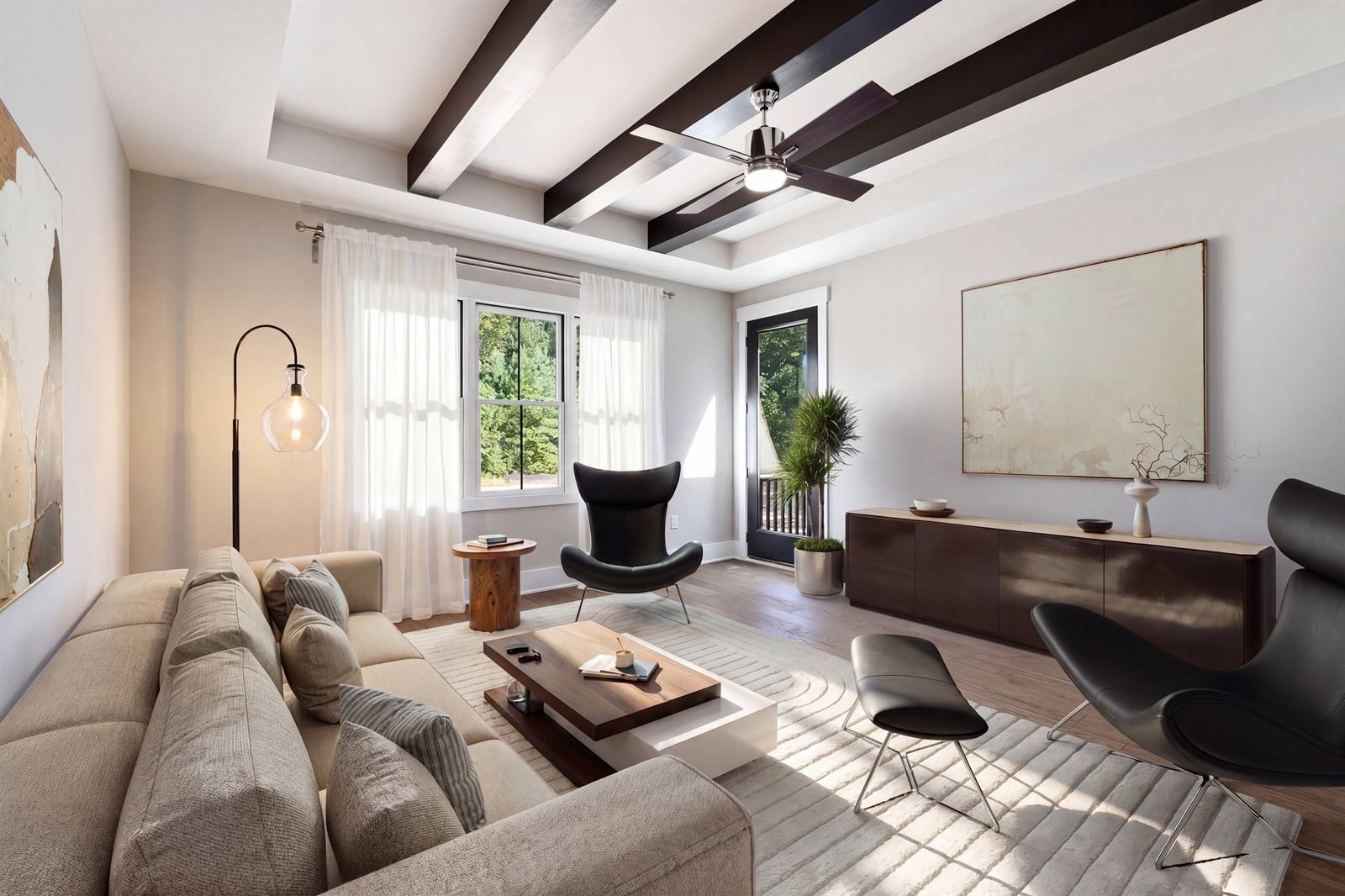 Living room with warm beige walls, dark wood ceiling beams, an oat sofa, walnut sideboard and a warm bulb floor lamp