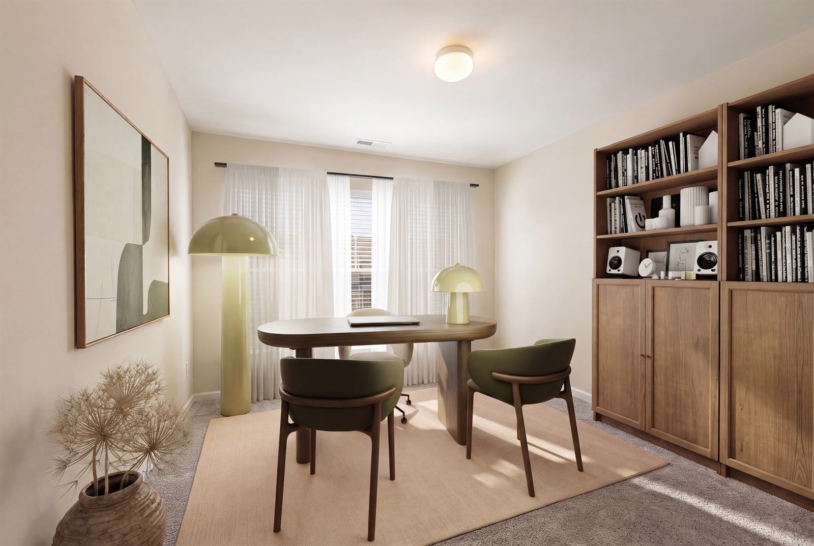 Home office with cream walls, an oat rug, walnut desk and shelving, olive chairs and two glowing lamps