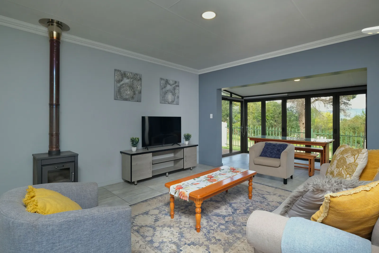 Furnished living room with a sofa, armchair, coffee table and rug before AI furniture removal