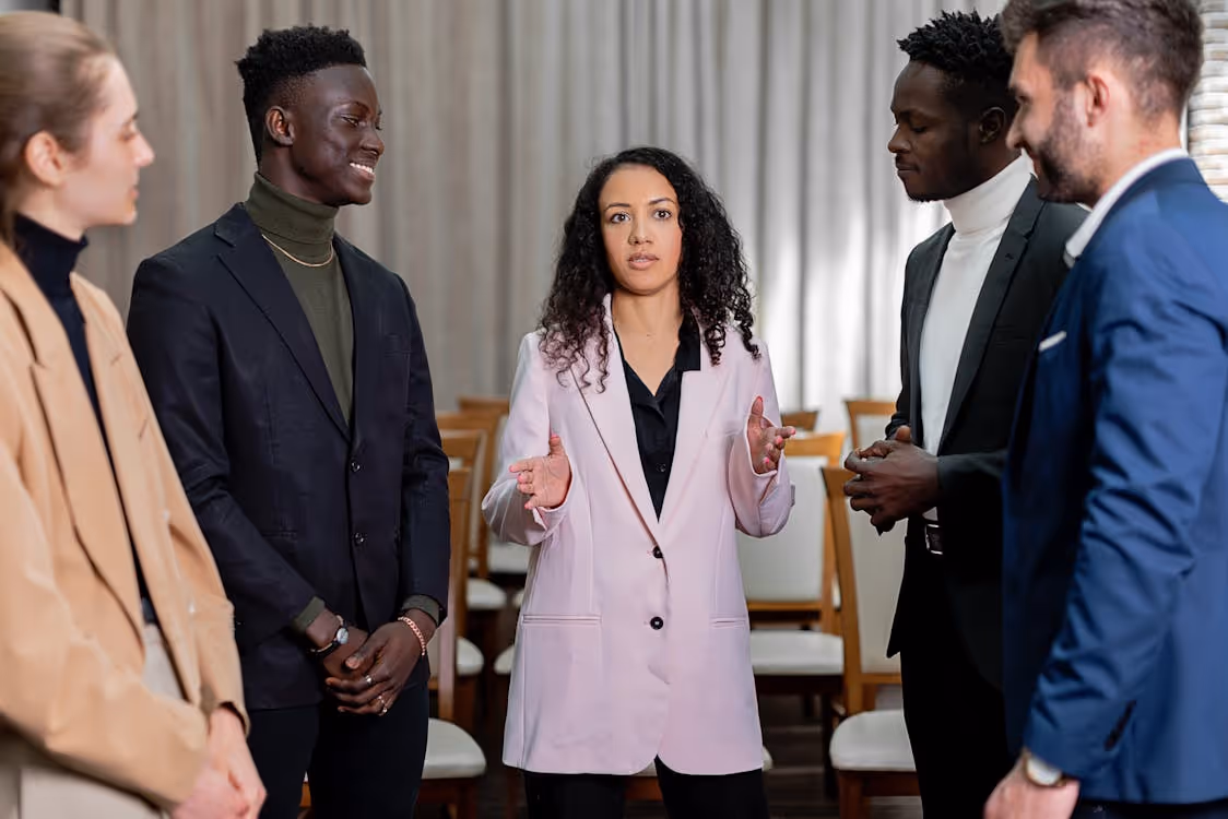 Free A diverse group of professionals in business attire discussing ideas in a meeting setting. Stock Photo