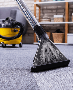 Ein Staubsauger entfernt die Verschmutzung auf einem Teppich