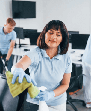 Reinigungspersonal reinigt einen Monitor im Büro