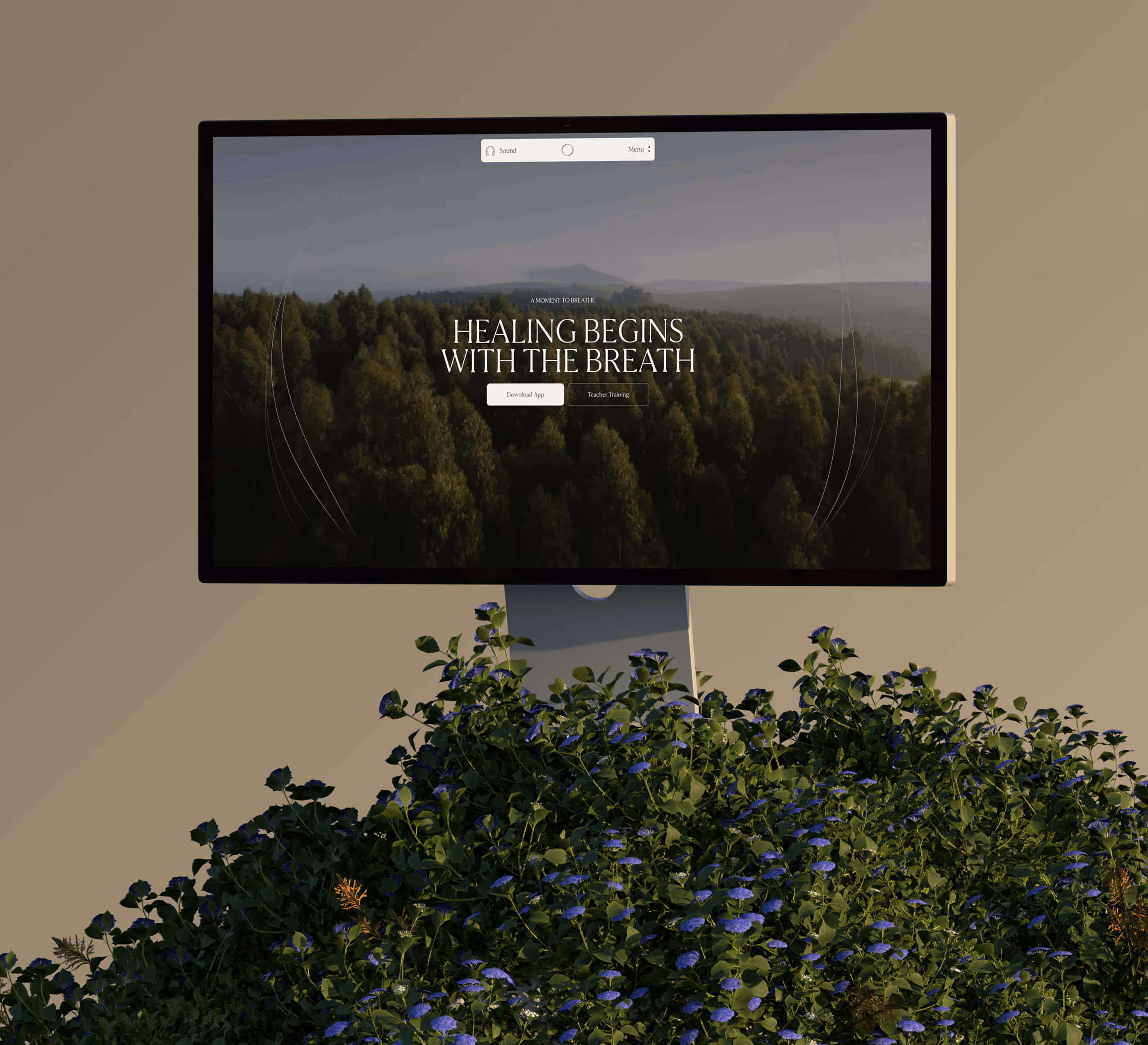 Computer monitor showing a forest landscape with text 'Healing Begins With The Breath' and buttons for downloading an app and teacher training.