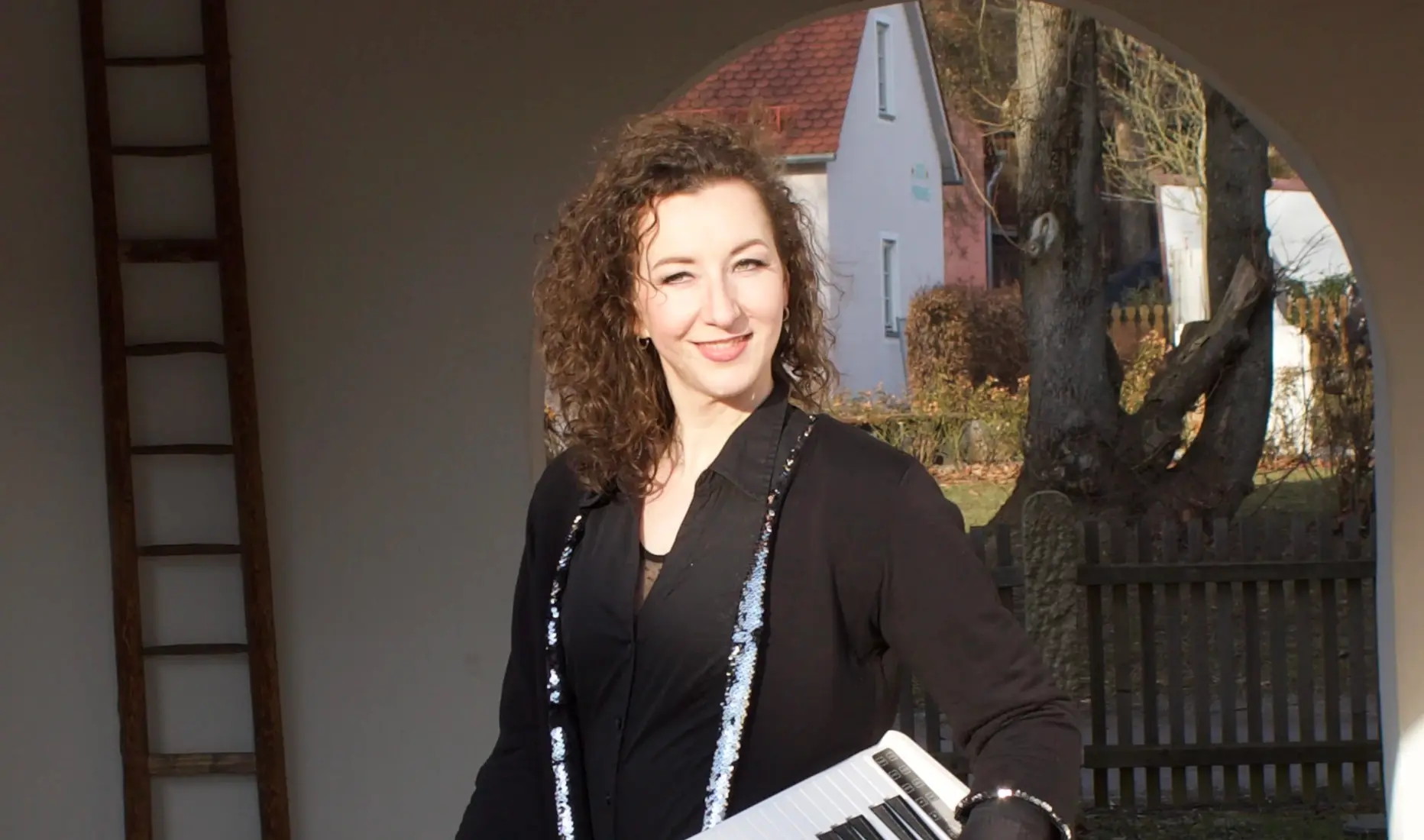 Wedding singer Keyrina holding a keytar outdoors – live music for ceremonies, baptisms and events in Bavaria