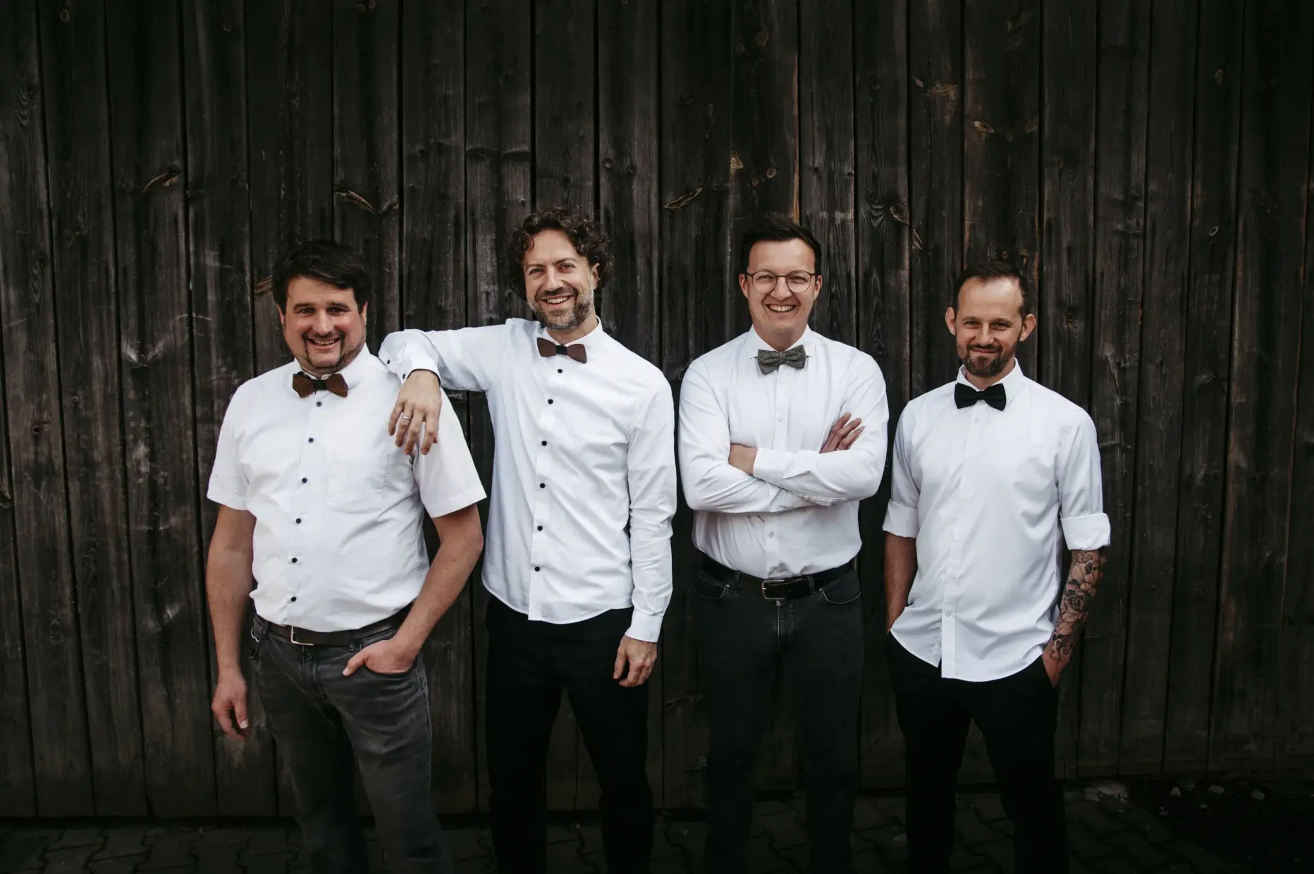 Die Musiker der Partyband Foxy Gentlemen vor einem rustikalen Scheunentor.