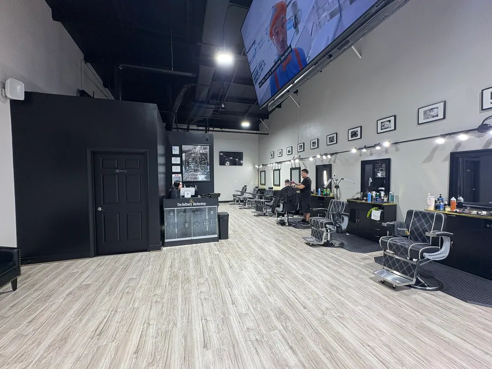Refinery Barbershop: Barber stations and new flooring beneath the exposed ceiling