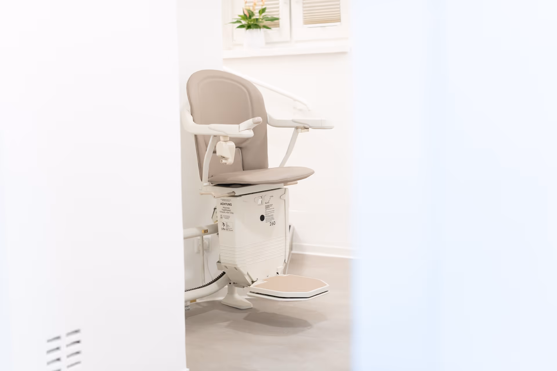 Abbildung eines Lifta-Treppenlifts mit heruntergeklappter Sitzfläche am Ende einer Treppe.