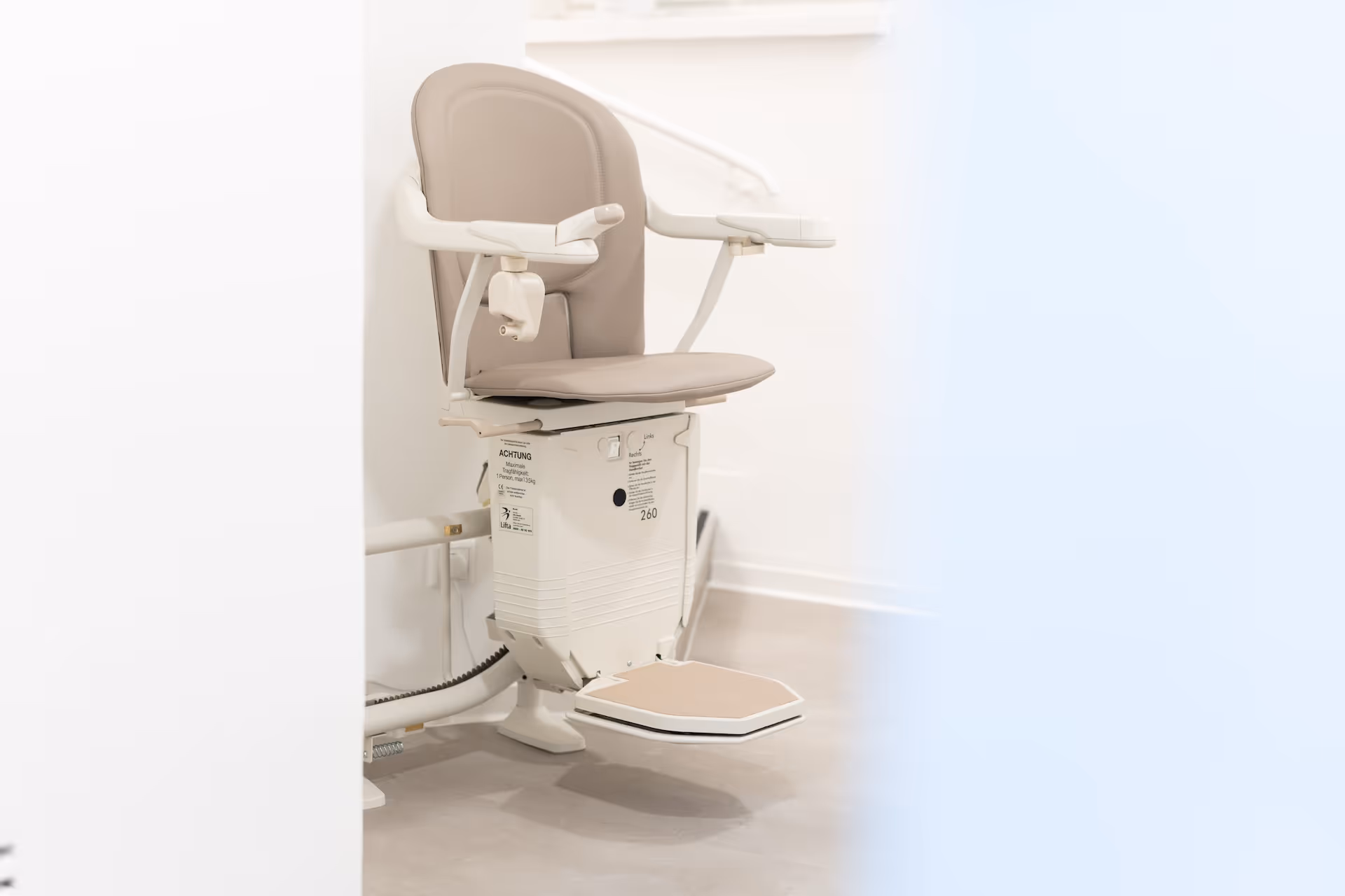 Abbildung eines Lifta-Treppenlifts mit heruntergeklappter Sitzfläche am Ende einer Treppe.