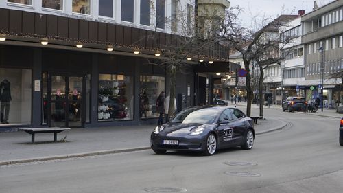 Tesla med Falk Trafikkskole-logo kjører gjennom