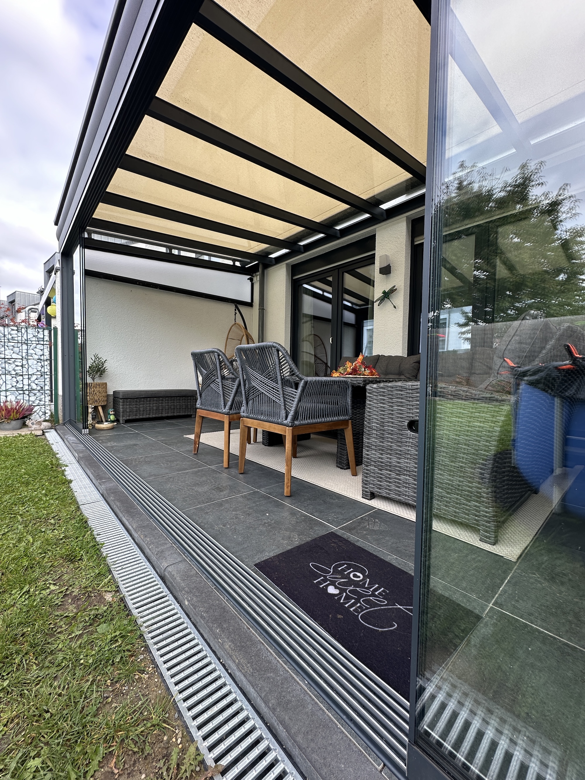 Ein Kaltwintergarten mit Glasdach, Aufglasmarkise und Glasschiebewände