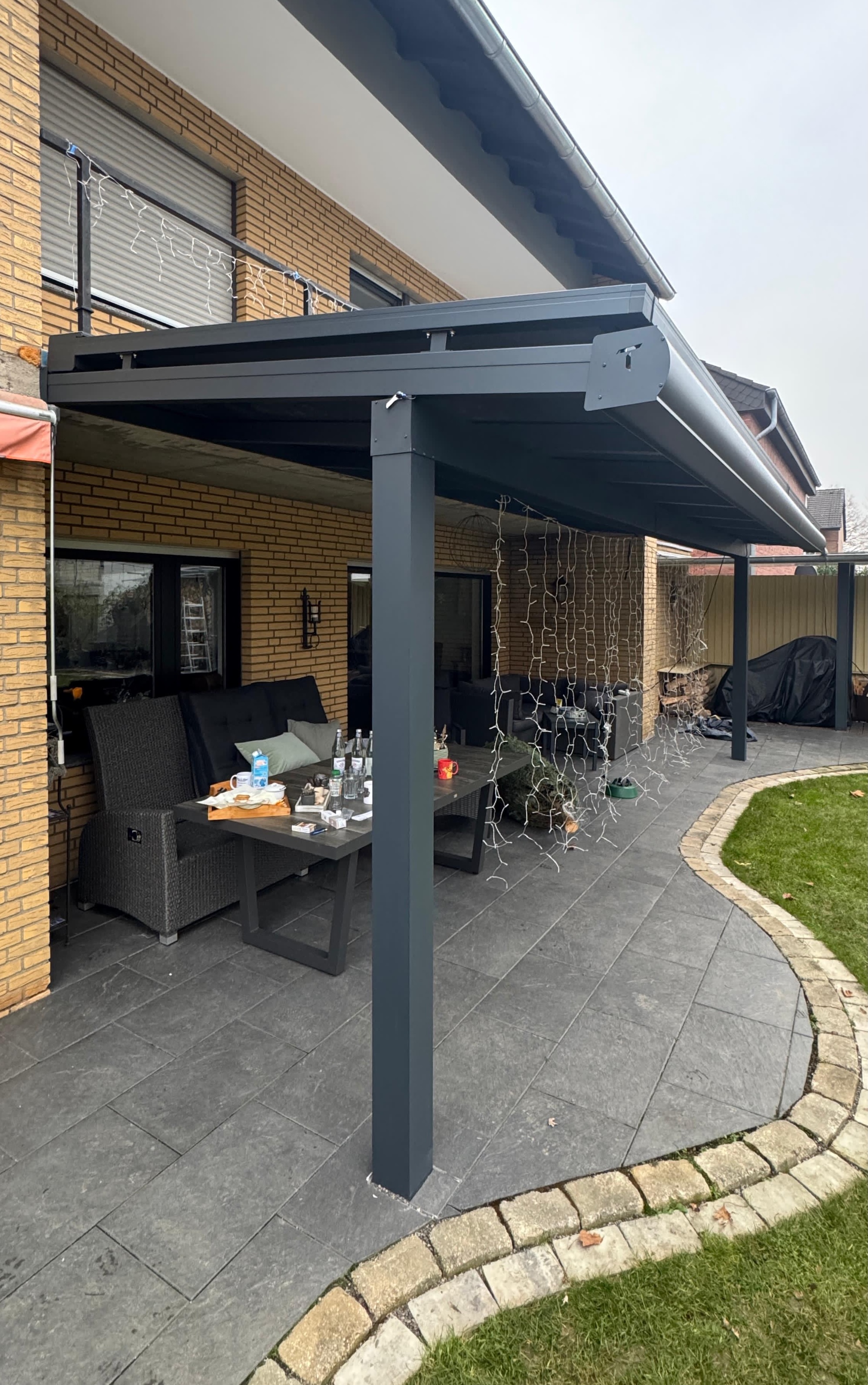 Eine Terrassenüberdachung mit Glasvorsprung aus Aluminium und Glas mit Aufdachmarkise
