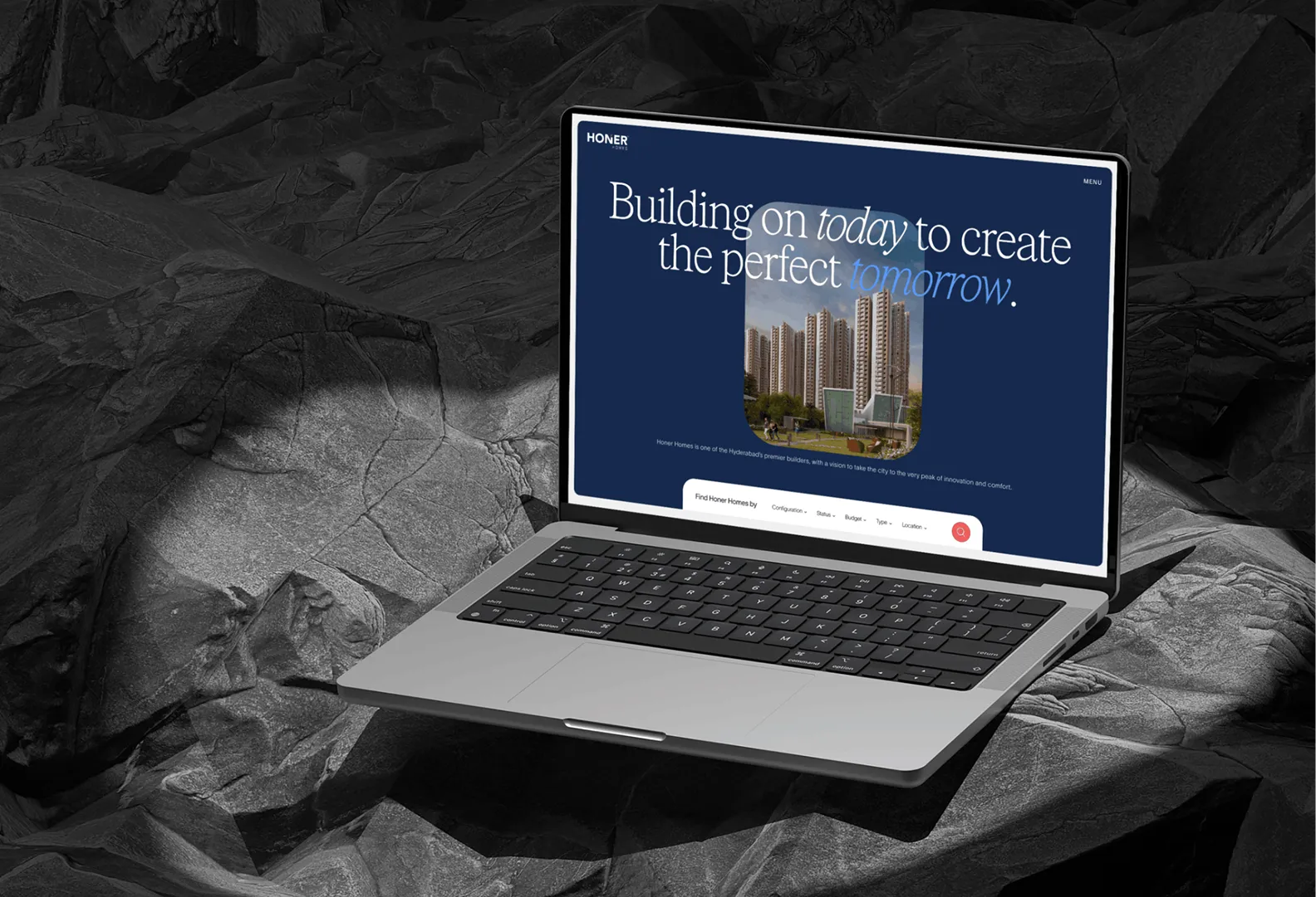 Laptop displaying a website with text 'Building on today to create the perfect tomorrow' and a photo of modern high-rise buildings.