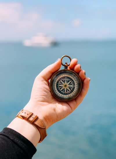 A compass with a sea blurred background