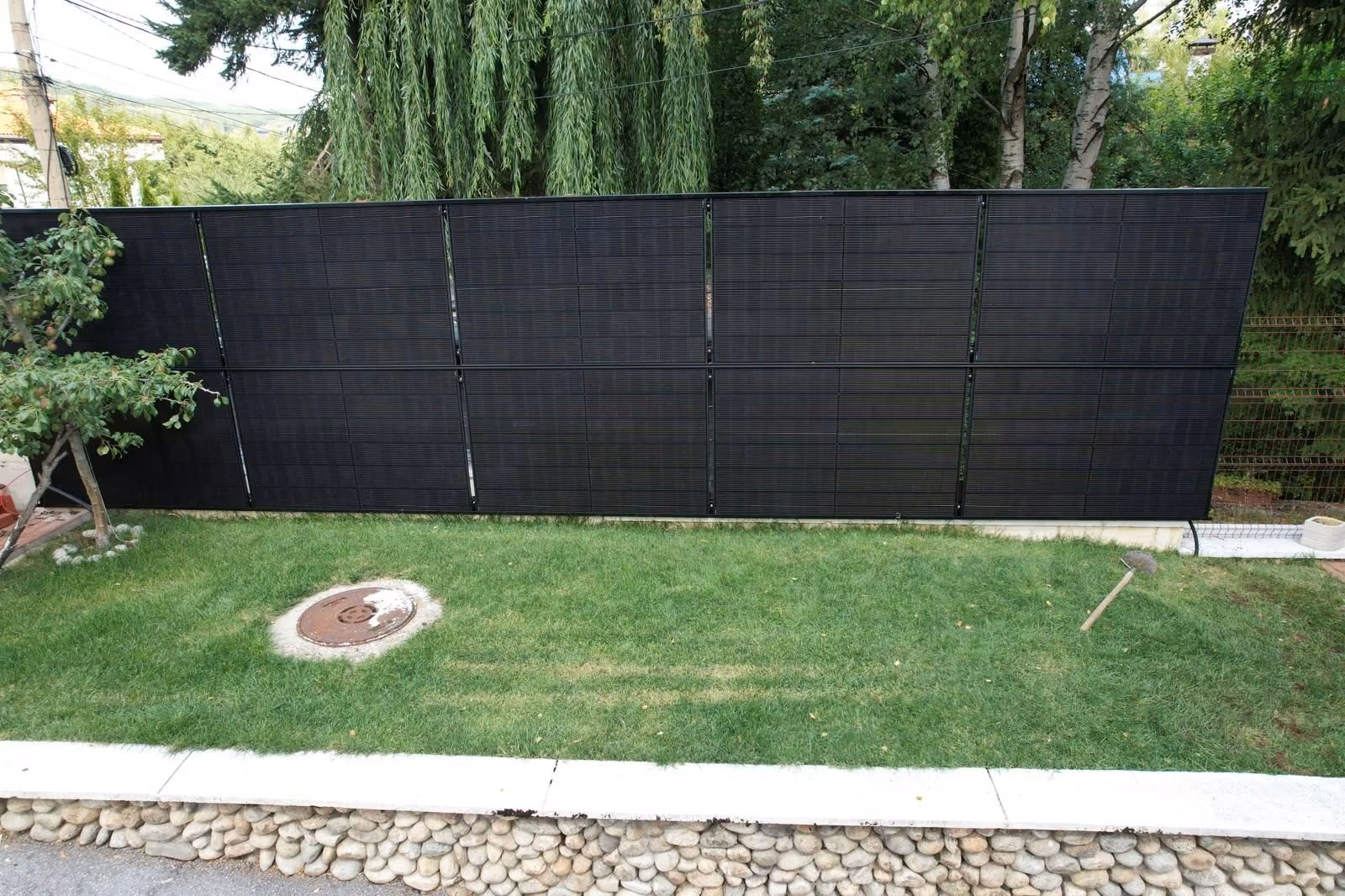 RAULI FENCE solcellsstaket med svarta paneler längs tomtgränsen i Bulgarien