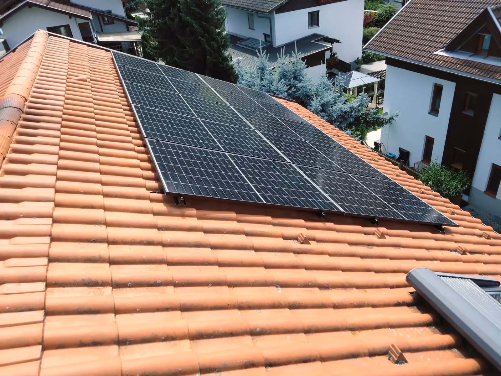 Solar panels on a pitched clay tile roof mounted with the RAULI BLACK system in Austria