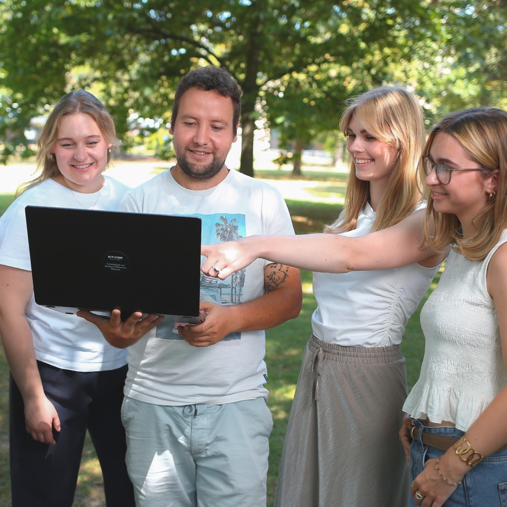 Vier Mitarbeiter von KITICON Global Networks mit Laptop