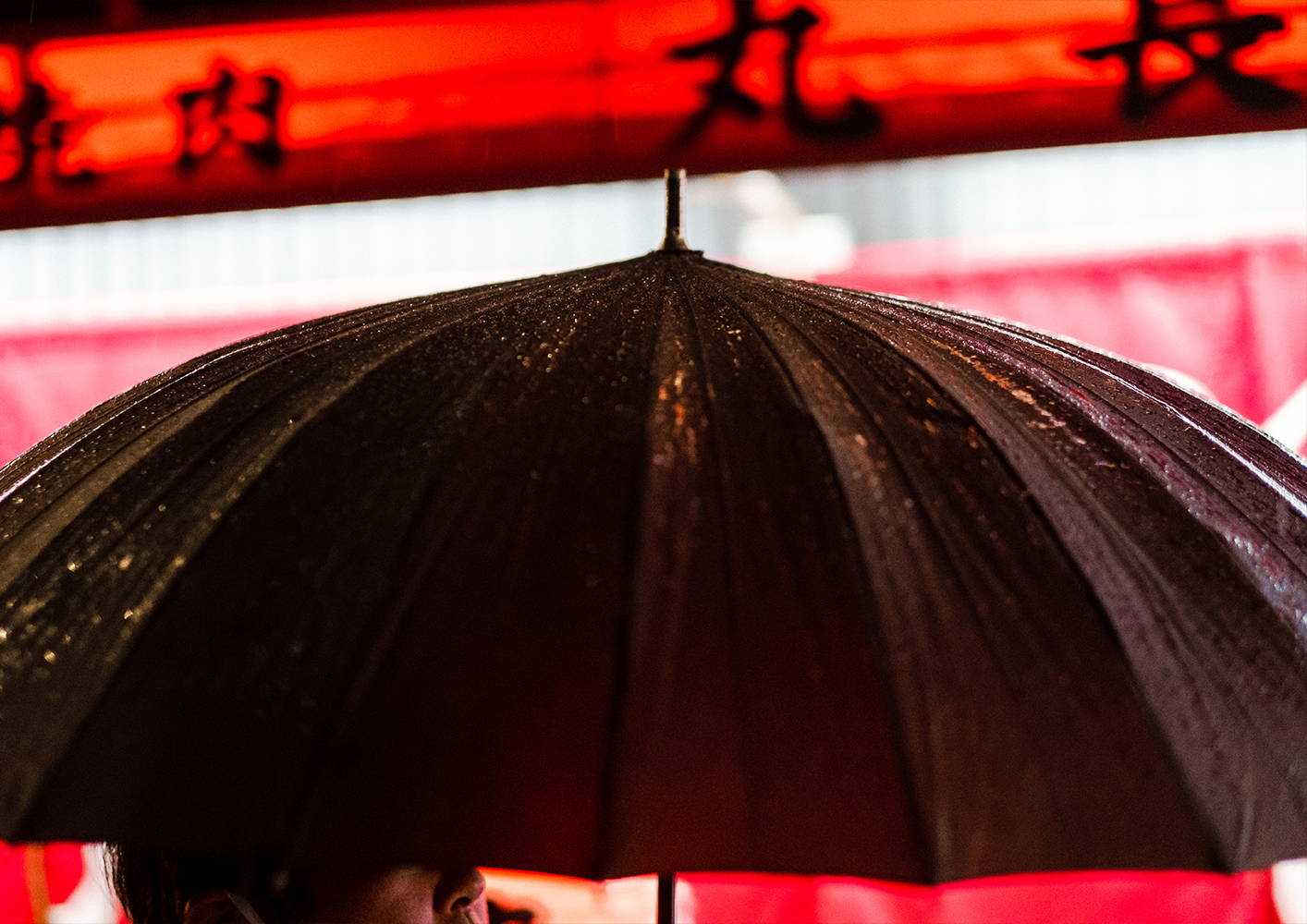 Photo of a woman holding an umbrella and her skirt with the other hand, walking down the street in the pouring rain,