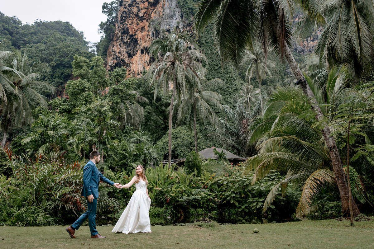 wedding couple kisses underneath palm trees