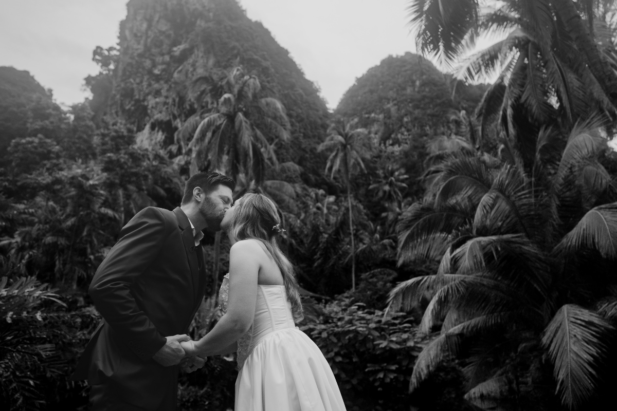 wedding couple between palm trees in krabi thailand