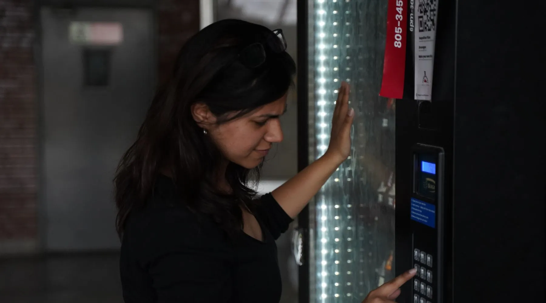 a woman paying at a vending machine