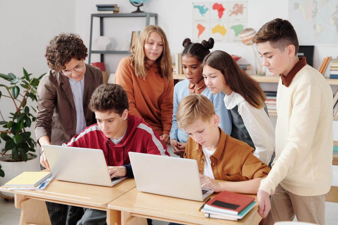Diverse students collaborating on laptops in a classroom setting