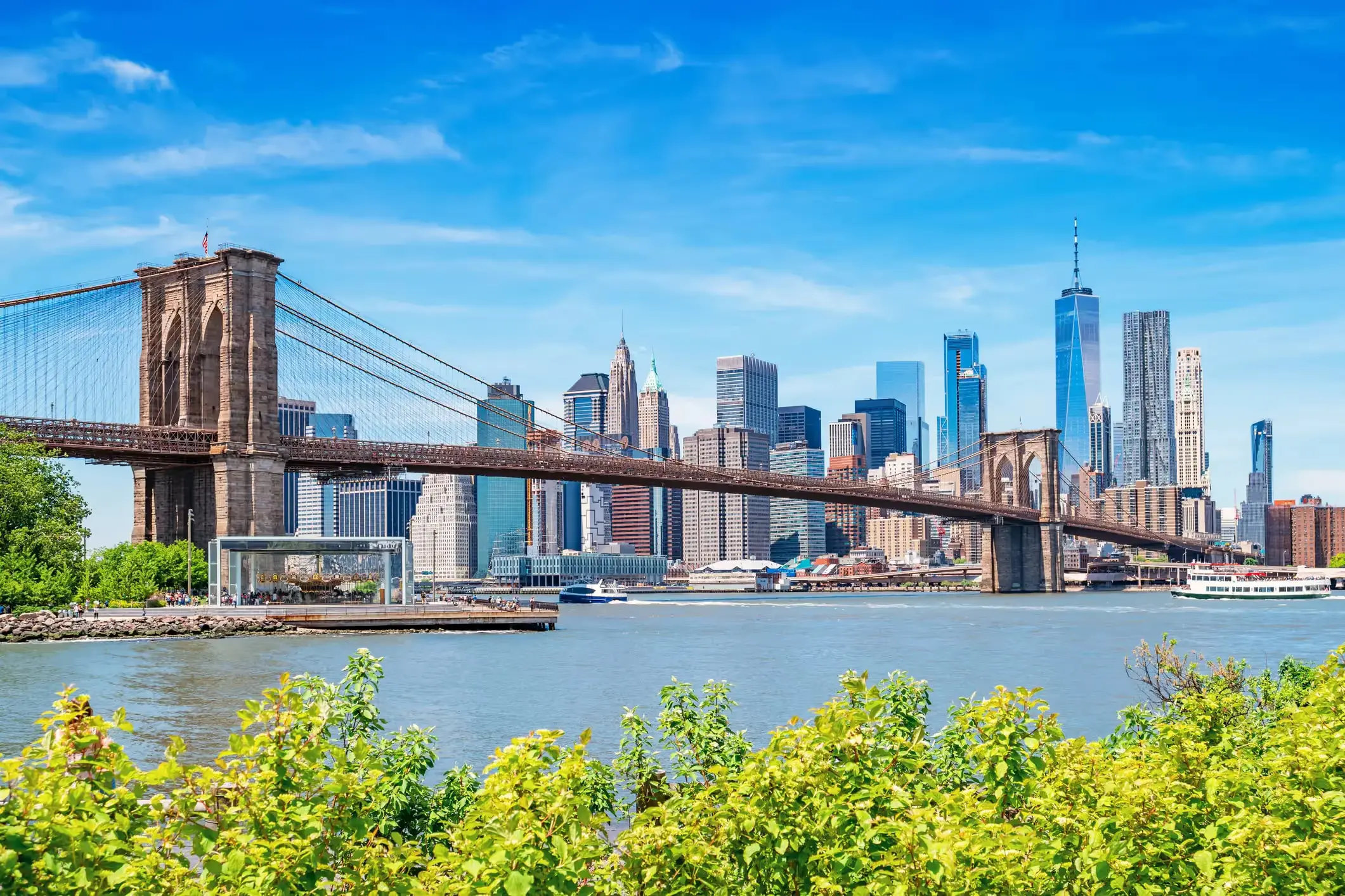 Walking across the Brooklyn Bridge with the New York City skyline in the background