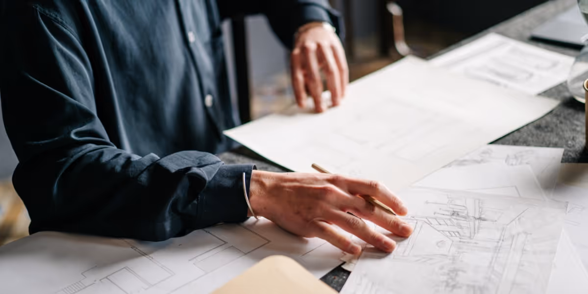 Person hand on a desk overlooking documents