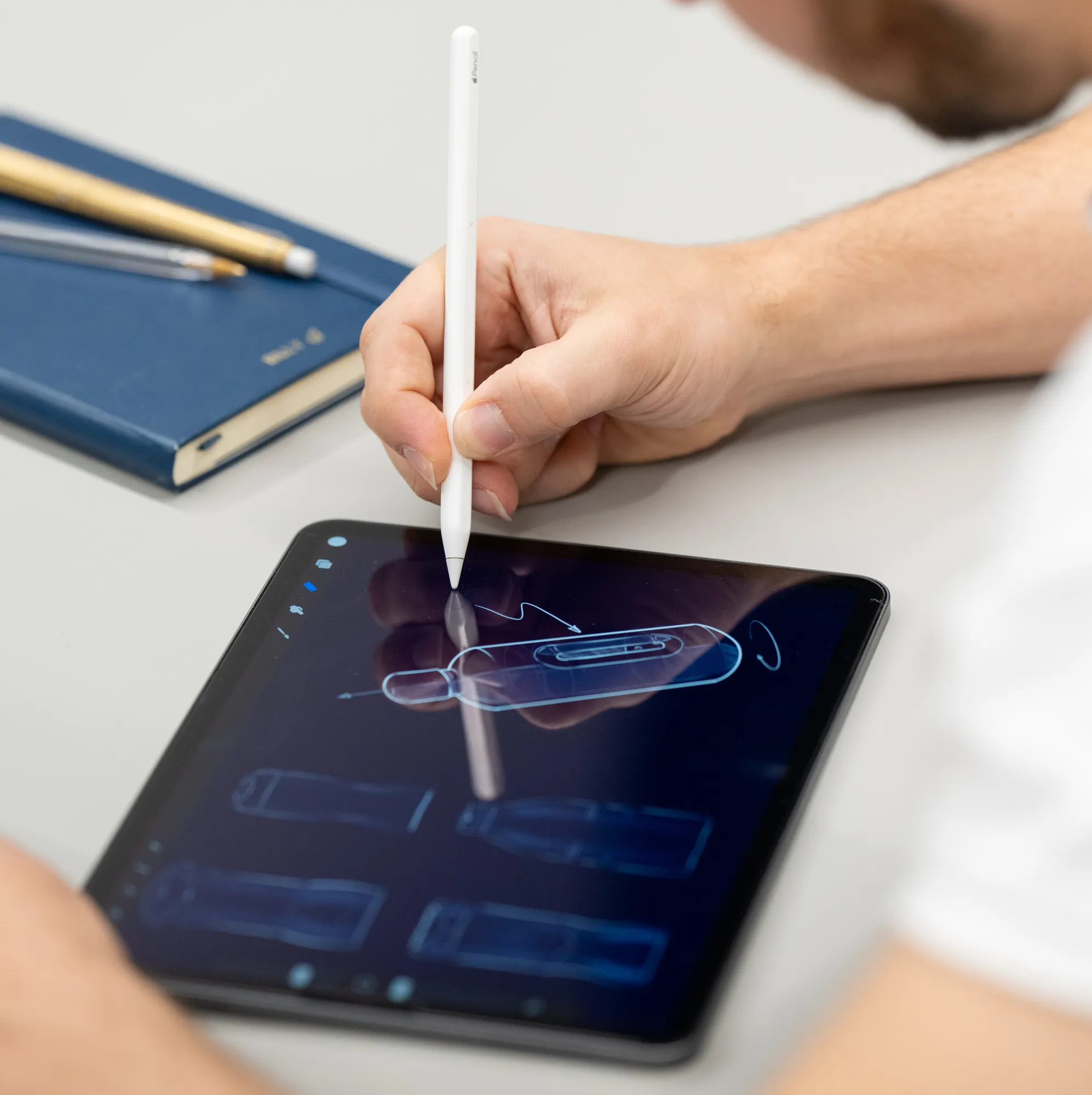 Person sketching a design of a water bottle on an iPad.