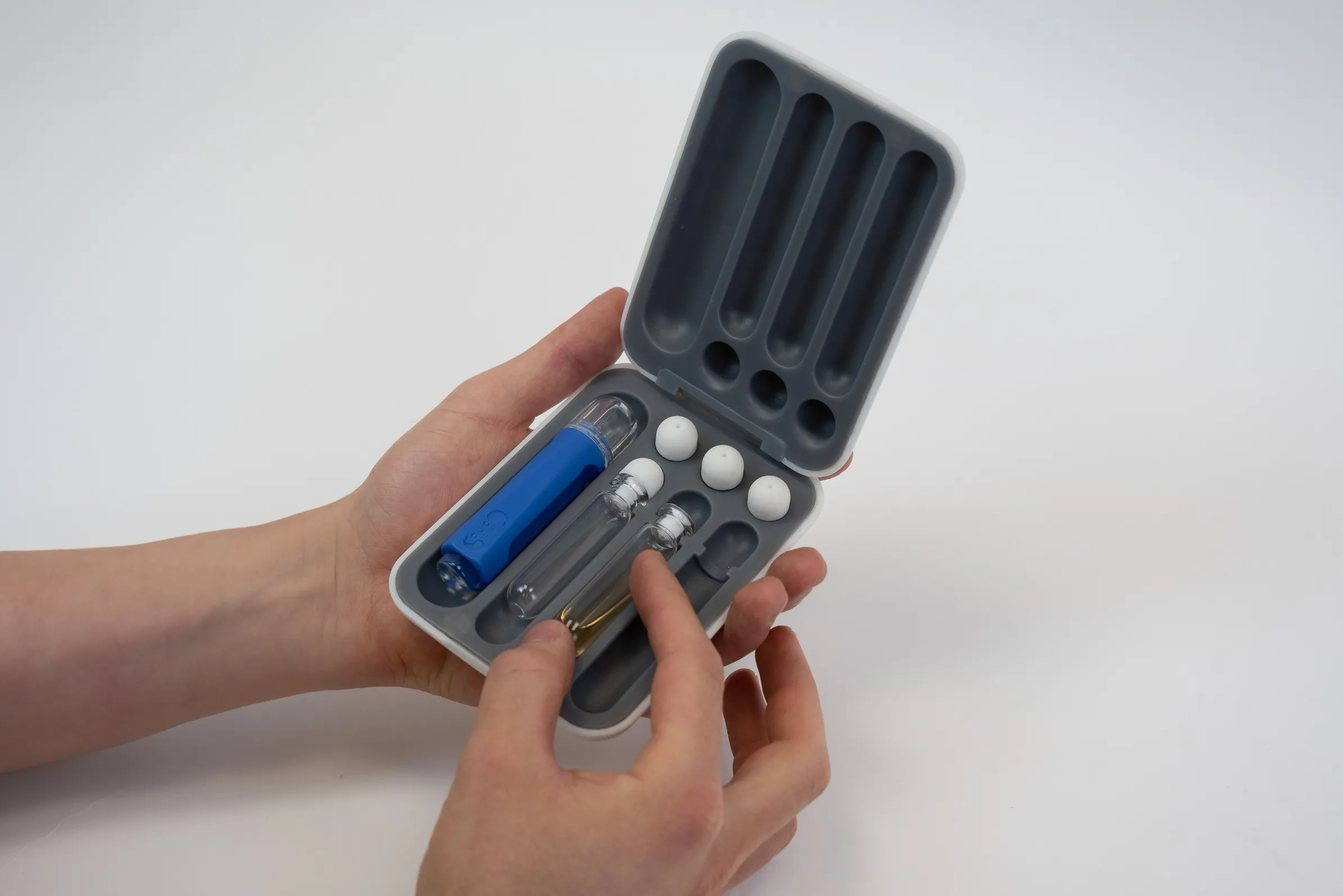 Person holding a prototype of a carrying case for Pacifi's probiotic applicator kit.