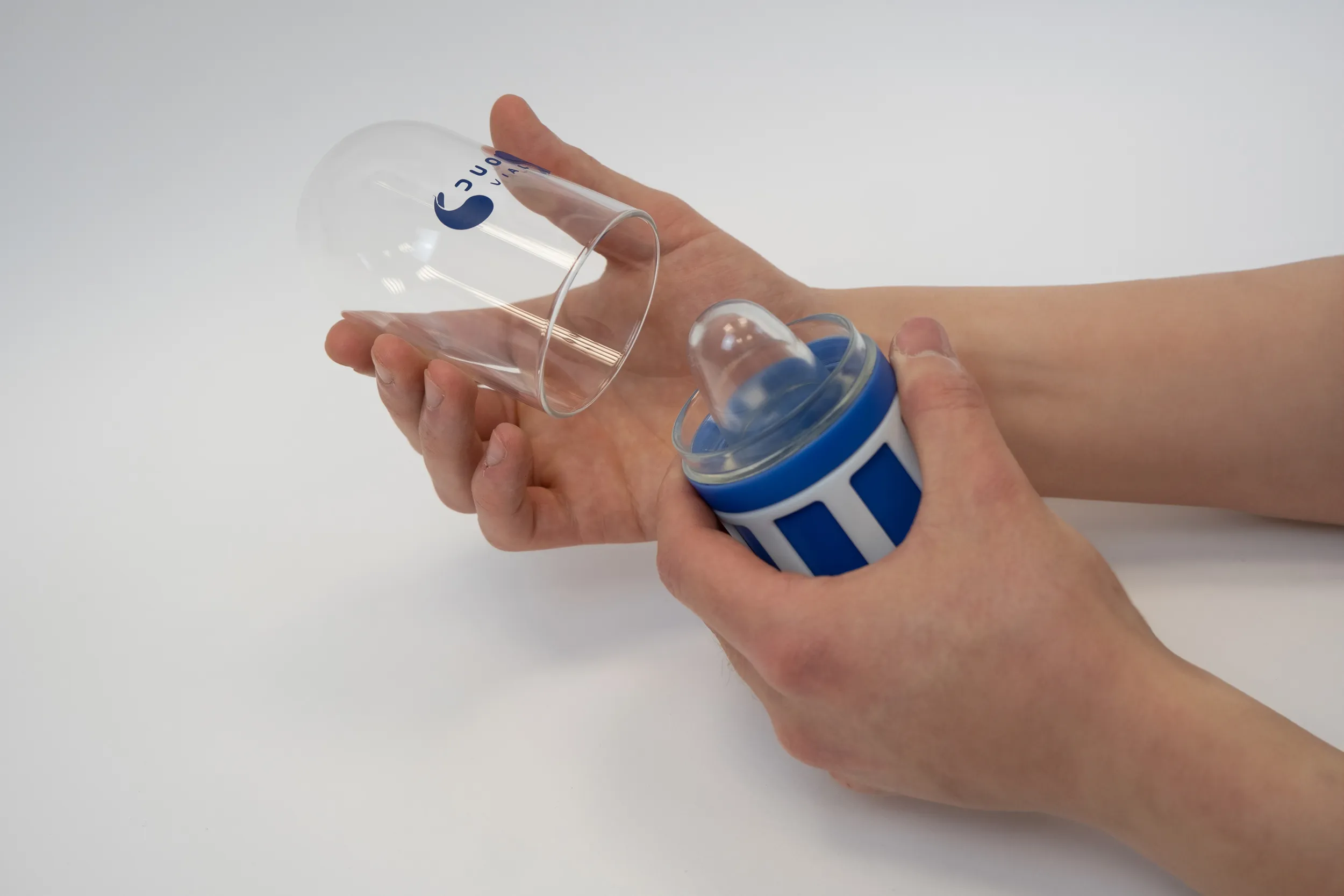 Person holding a blue and white visual model, showcasing Duo-Vial's patented lasered glass technology.