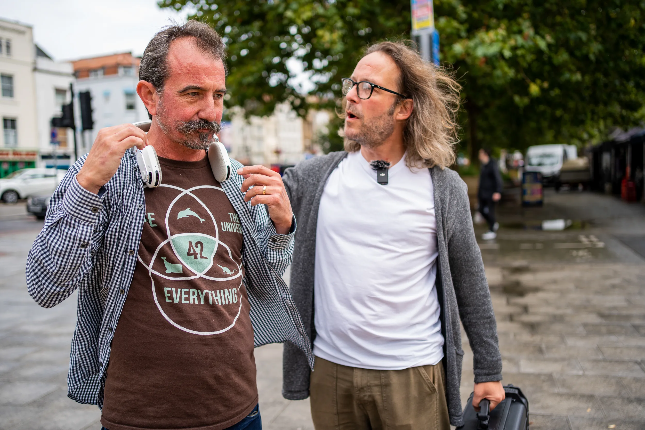 Jim Reeves walking with a visually impaired man in the street, showing him how the Sixth Sense assitive device functions.