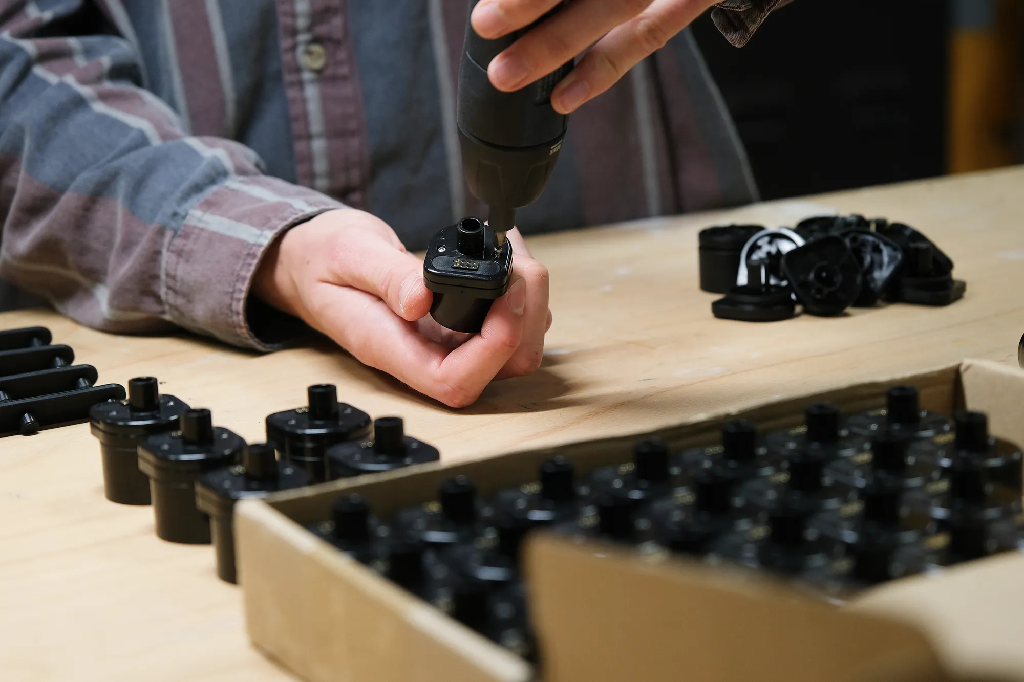 A person assembling a batch of Scentient Escents scent pods.