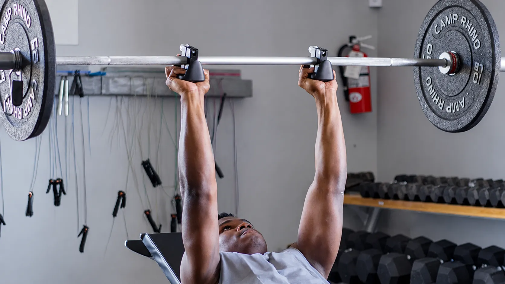 Man lifting a weight bar with GripMod grip attachments.