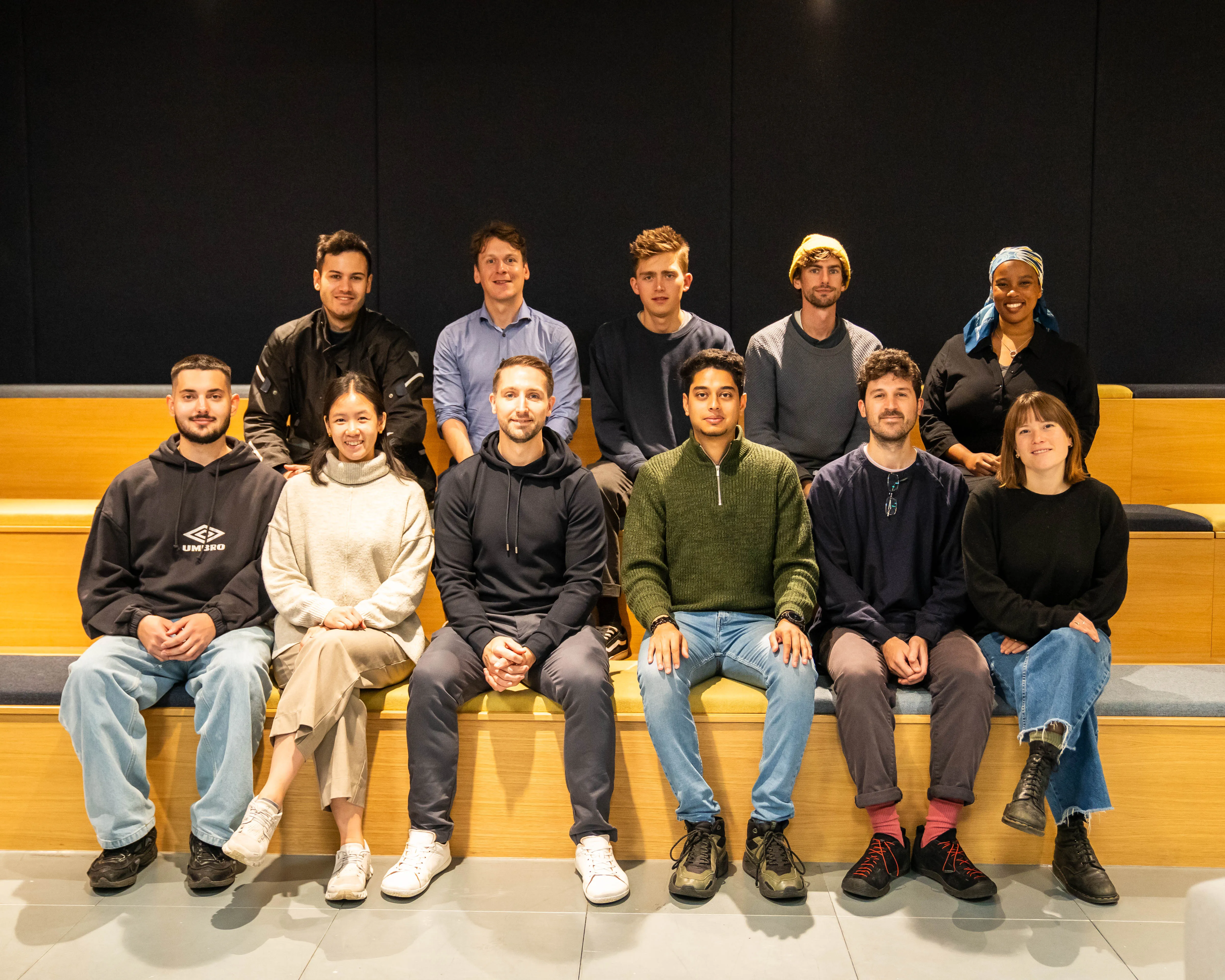 Members of a CRL Accelerator cohort, seated together on a bench.